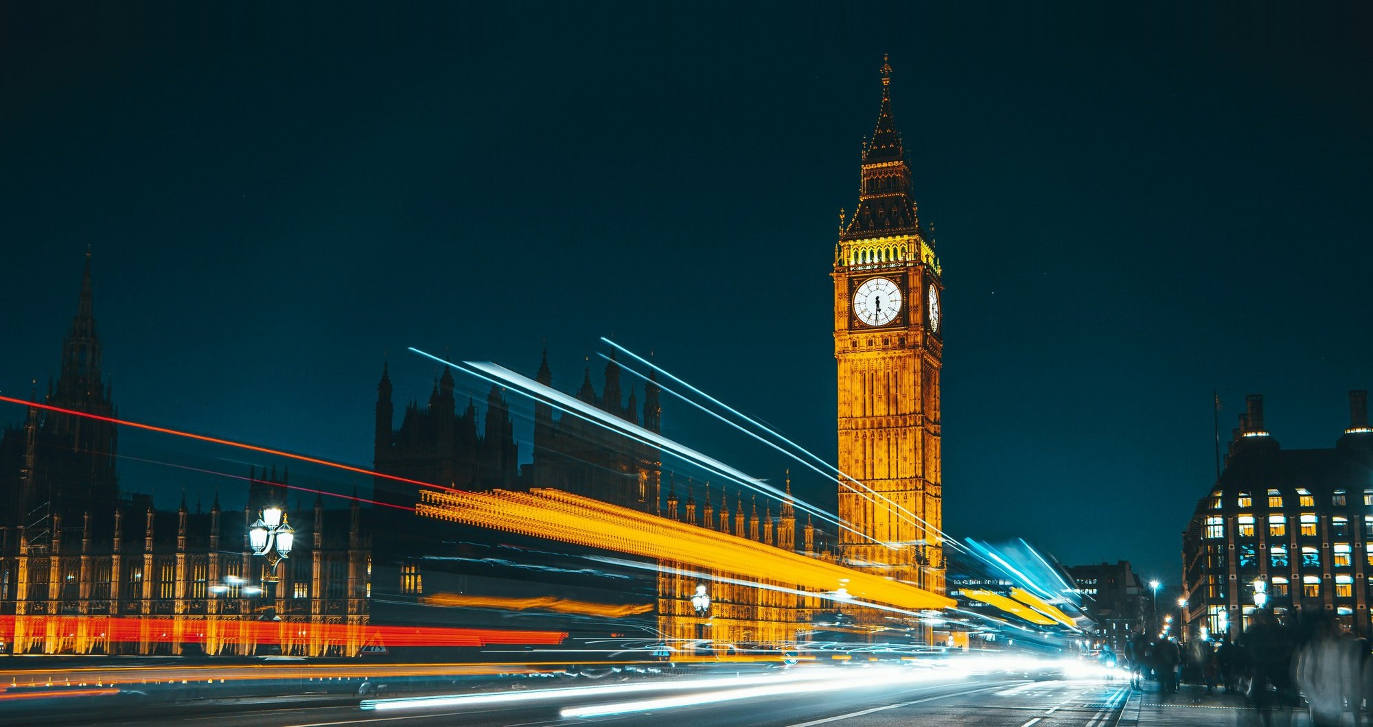 Big Ben and the Houses of Parliament at night, with traffic light trails on Westminster Bridge